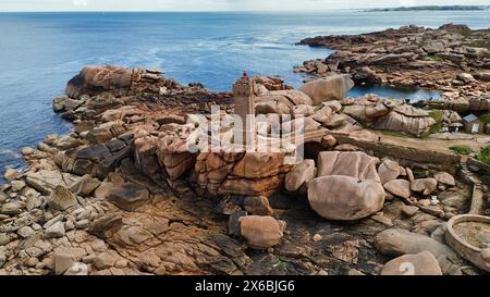Drohnenaufnahmen des Phare de Men Ruz Ploumanac'h Perros-Guirec Frankreich, des ikonischen rosa Granit-Leuchtturms, der auf zerklüfteten Felsformationen thront Stockfoto