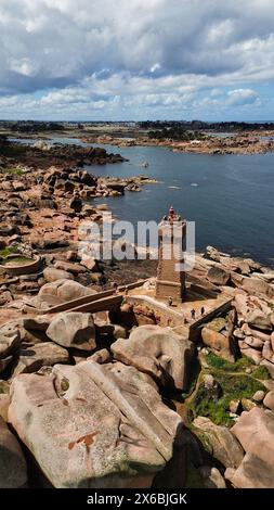 Drohnenaufnahmen des Phare de Men Ruz Ploumanac'h Perros-Guirec Frankreich, des ikonischen rosa Granit-Leuchtturms, der auf zerklüfteten Felsformationen thront Stockfoto