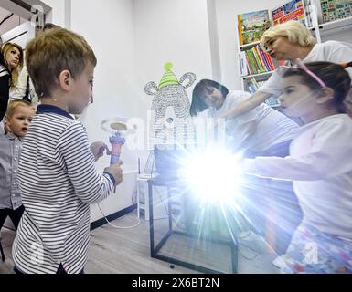 Nicht exklusiv: ZAPORIZHZHIA, UKRAINE - 10. MAI 2024 - Kinder werden von einem Projektor in einer modernisierten Familienbibliothek versammelt, die sie offiziell eröffnet hat Stockfoto