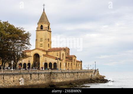 Blick auf die Kirche San Pedro in Campo Valdés, einen katholischen Tempel, das Wasser und das Meer an einem bewölkten Tag. Gijón, Asturien, Spanien. Stockfoto