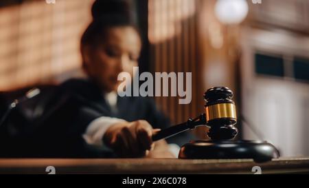 Gerichtsverfahren in der Sitzung: Ehrenwerte Richterin, die das Urteil ausspricht, streikt Gavel. Konzentrieren Sie sich auf Mallet, Hammer. Filmische Aufnahme eines dramatischen nicht-schuldig-Urteils. Nahaufnahme. Stockfoto