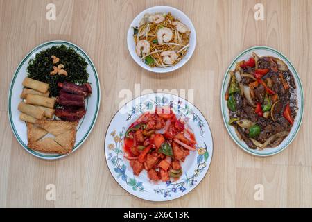 Chinesisches Essen: King Garnelen Chow mein, süß-saures Huhn, Rindfleisch in schwarzer Bohnensoße und gemischte Vorspeisen mit Rippchen, Krabbentoast, Meeresgras und Frühlingsrollen Stockfoto