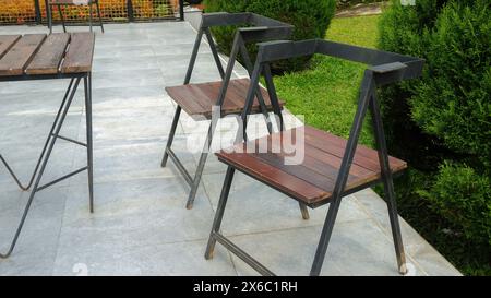 Eisenstuhl mit stabilem Holzgestell im Garten Stockfoto