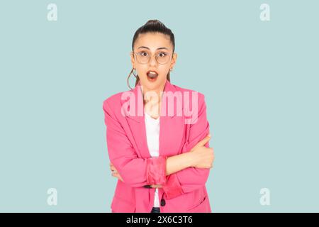 Porträt einer attraktiven verwunderten Frau unglaubliche Nachrichtenreaktion. Wunderschönes schockiertes weißes Brünette Mädchen trägt Brille, formelle rosa Jacke. Stockfoto