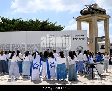 Latrun, Israel. Mai 2024. Jugendliche tragen die israelische Nationalflagge an einer Gedenkstätte im Latrun Tank Museum am 76. Unabhängigkeitstag Israels am Dienstag, den 14. Mai 2024. Die Feierlichkeiten zum Unabhängigkeitstag werden mit dem andauernden Krieg zwischen Israel und der Hamas gedämpft. Foto: Debbie Hill/ Credit: UPI/Alamy Live News Stockfoto