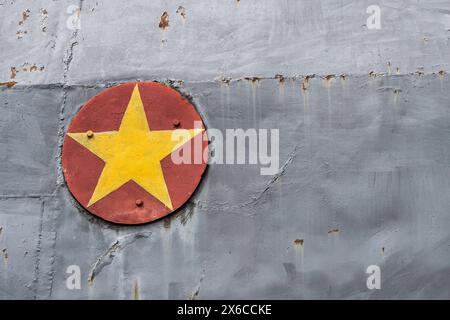 Symbol der vietnamesischen Flagge, rot mit gelbem Stern, vor einem Metallgrauen Metallhintergrund. Platz zum Kopieren Stockfoto