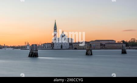 Blick auf die Kirche San Giorgio Maggiore, bei Sonnenaufgang, über die Lagune von Venedig. Lange Exposition, um das Wasser zu glätten Stockfoto