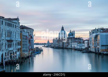 Sonnenaufgang über dem Canal Grande in Venedig, Italien, mit Blick auf die majestätische Basilika di Santa Maria della Salute. Lange Belichtung Stockfoto