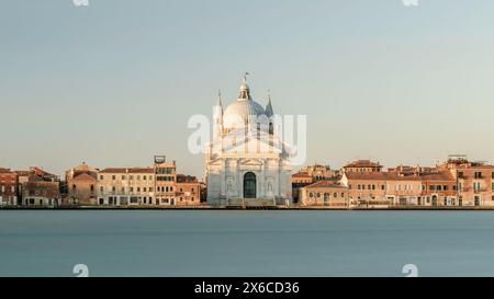 katholische Kirche Chiesa del Santissimo Redentore und Reihe von Gebäuden am Ufer von fondamenta des Kanals der Insel Giudecca in der Lagune von Venedig bei Sonnenaufgang Stockfoto