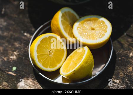 Frische Zitronen ordentlich auf einem rustikalen Holztisch angeordnet, bereit für erfrischende Limonade oder pikante Rezepte Stockfoto