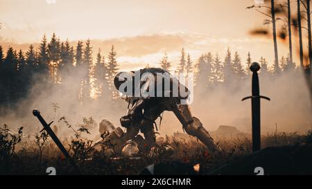 Dark Age Battlefield: Brutaler Kampf um zwei gepanzerte mittelalterliche Ritter, die Feinde mit Schwert töten. Die Schlacht der bewaffneten Krieger. Dramatische Szene, filmischer Rauch, Licht in historischer Nachstellung Stockfoto