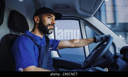 Porträt des stilvollen Latin Delivery Truck Driver on the Road. Happy Professional fährt sorgfältig, liefert Online-Bestellungen, E-Commerce-Waren, Lebensmittel, Medizin. Frontline Held Macht Arbeit. Im Fahrzeug Stockfoto