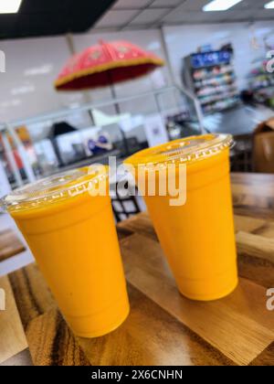 Zwei Mango Lassi Getränketassen in modernem Restaurant, Nahperspektive Stockfoto