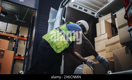 Handsome Black männlicher Mitarbeiter im Einzelhandelslager lädt Kartons in den Lieferwagen. Logistics Retail Center, Bereitstellung von Online-Bestellungen im E-Commerce, Lebensmittel- und Medizinprodukte. Abendaufnahme Mit Niedrigem Winkel Stockfoto