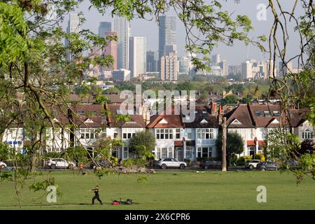 Mit den Hochhäusern der Nine Elms in Battersea und einer südLondoner Skyline in der Ferne übt eine Person am 10. Mai 2024 im Ruskin Park, einem öffentlichen Grüngelände in Lambeth, Kampfkunst aus. Stockfoto