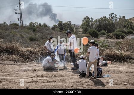 Sderot, Israel. Mai 2024. Israelische rechte Siedler machen ein Barbecue, während Rauch am israelischen Unabhängigkeitstag aus dem Gazastreifen steigt. Quelle: Ilia Yefimovich/dpa/Alamy Live News Stockfoto