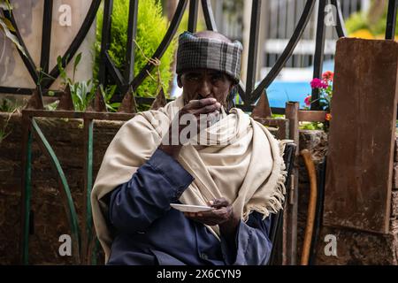 Älterer Mann, der traditionell gekleidet ist, trinkt echten äthiopischen Kaffee in der Kaffeebar in Addis Abeba Stockfoto