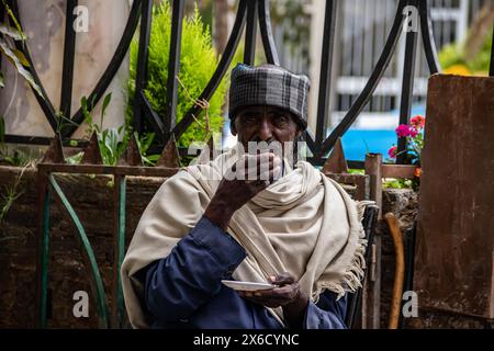 Älterer Mann, der traditionell gekleidet ist, trinkt echten äthiopischen Kaffee in der Kaffeebar in Addis Abeba Stockfoto