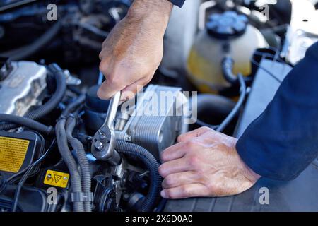 Mann, Nahaufnahme und Motor mit Werkzeugen für Wartung in der Werkstatt, Inspektion oder Wartung am Auto. Mechaniker männlich, automatisch und auf Problem mit Öl oder prüfen Stockfoto