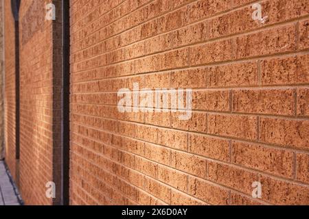 Strukturierte Ziegelwand in warmem Licht, angewinkelte Perspektive Stockfoto