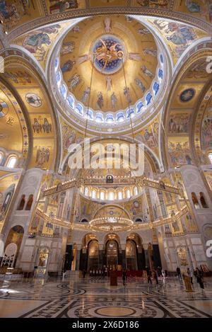 Verzierte und dekorative Innenausstattung der Kirche St. Sava. Eine der größten orthodoxen Kirchen der Welt. Die Leute im Inneren zeigen die Waage. April 2024. Stockfoto