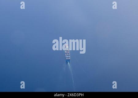 Ein Frachtcontainer-Schiff aus der Vogelperspektive bei Sonnenuntergang Stockfoto