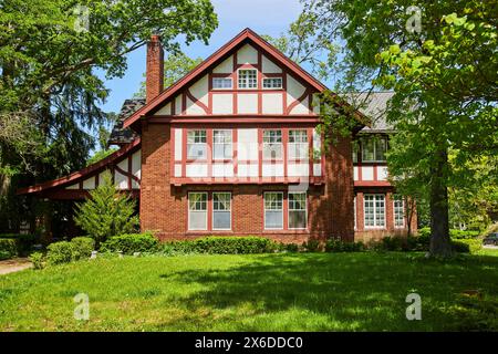 Traditionelles Tudor-Haus in üppigem Grün, sonnige Vorstadtlage Stockfoto