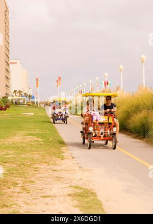 Touristen, die eine Fahrt mit Familienfahrrädern am Virginia Beach in Chesapeake Bay, USA, genießen. Stockfoto