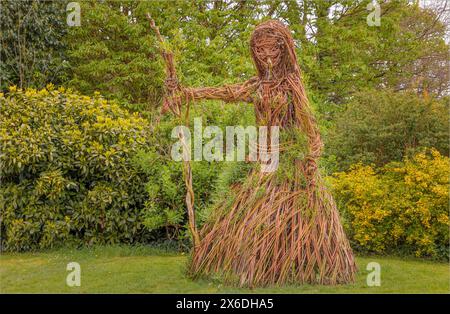 Weidendame in einem langen Kleid mit einem Stab aus Weide, mit ein paar Stäben, die wieder zum Leben erweckt werden Stockfoto