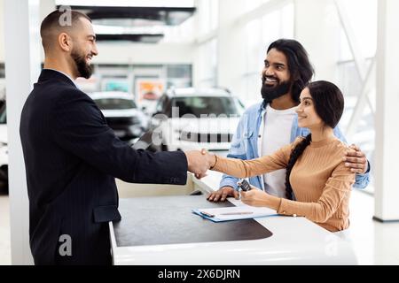 Mann schüttelt Hand mit Frau im Car Showroom Stockfoto