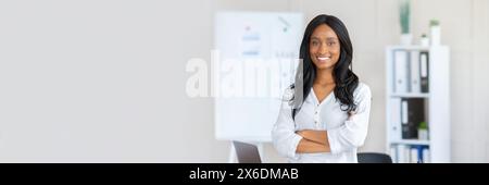 Porträt einer glücklichen afroamerikanischen Geschäftsfrau, die mit überkreuzten Armen steht Stockfoto