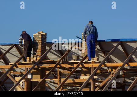 Dorfbewohner bauen gemeinsam ein Dach. Stockfoto