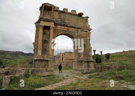 Touristen unter dem Arch de Caracalla mit Blick auf den Tempel des Gens Septimia in Djemila in Algerien Stockfoto