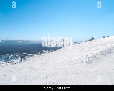 Weitläufiger Blick vom schneebedeckten Mount Ruapehu über die Landschaft und zwei Berge im Tongariro-Nationalpark. Stockfoto