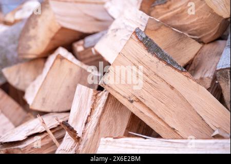 Nahaufnahme von frisch gehacktem Brennholz auf einem rustikalen Stapel, mit verschiedenen natürlichen Texturen und Holztönen Stockfoto
