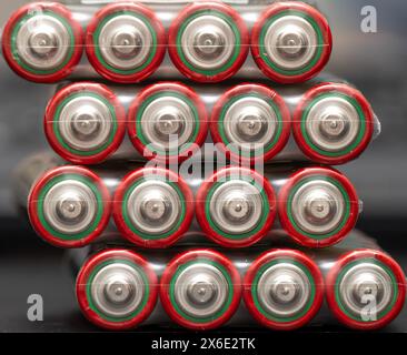 Nahaufnahme von aa-Batterien in symmetrischen Reihen mit leuchtenden roten und grünen Etiketten Stockfoto