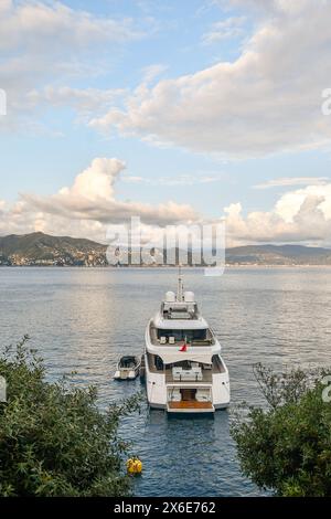 Hochwinkelansicht einer Mega-Yacht vor Anker in Cannon Bay, mit der Küste im Hintergrund bei Sonnenuntergang, Portofino, Genua, Ligurien, Italien Stockfoto