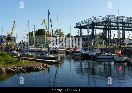 Klaipeda, Litauen - 11. August 2023: Zahlreiche Boote legen in einem belebten Hafen neben einer Brücke an, was eine geschäftige maritime Szene zeigt. Stockfoto