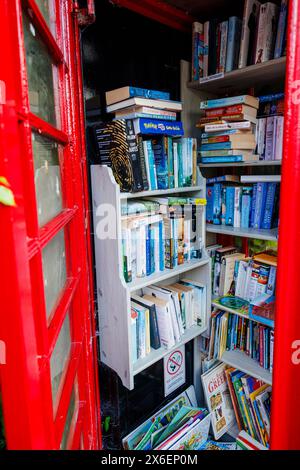 Eine traditionelle rote Telefonbox, die für Telefonie nicht mehr genutzt wurde, wird heute als Bibliothek in Callow End, einem Dorf im Malvern Hills District, Worcestershire, England, genutzt Stockfoto