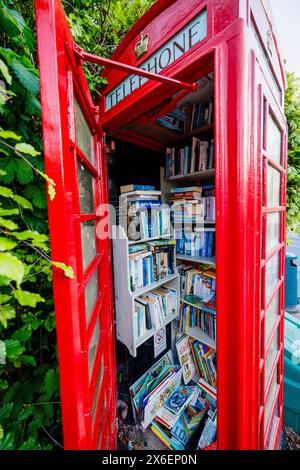 Eine traditionelle rote Telefonbox, die für Telefonie nicht mehr genutzt wurde, wird heute als Bibliothek in Callow End, einem Dorf im Malvern Hills District, Worcestershire, England, genutzt Stockfoto