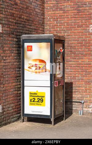 Werbeplakat am öffentlichen Telefonkiosk Stockfoto