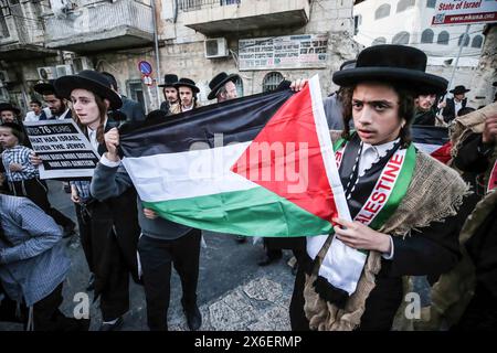 Jerusalem, Israel. Mai 2024. Ultra-orthodoxe jüdische Demonstranten marschieren mit antizionistischen Plakaten und palästinensischen Fahnen während einer Kundgebung gegen die Schaffung des Staates Israel in Jerusalems Nachbarschaft MEA Shearim. MEA Shearim in Jerusalem begeht das Land den 76. Jahrestag seiner Gründung. Quelle: SOPA Images Limited/Alamy Live News Stockfoto