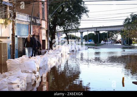 Porto Alegre, Brasilien. Mai 2024. Die Barrikade mit Sandsäcken, die die Zivilverteidigung eingerichtet hat, um die Gewässer des Lake Guaiba zu halten, die sich weiter erhebt, wurde am Dienstag (14.07.2024) zu einem Fußweg für die Bewohner des Zentrums. Eine Reihe von schweren Regenfällen, die durch ein extremes Wetter verursacht wurden, traf den Bundesstaat Rio Grande do Sul, verursachte Überschwemmungen und Überschwemmungen, die Menschen obdachlos und tot in verschiedenen Städten, die die gesamte Region in einen Zustand der öffentlichen Katastrophe gebracht. FOTO: Maxi Franzoi/AGIF Credit: AGIF/Alamy Live News Stockfoto