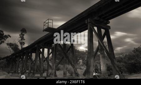 Schwarzweiß-Langzeitbelichtung einer stillgelegten Eisenbahnbrücke Stockfoto