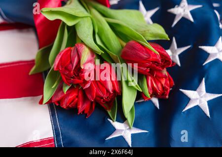 Wunderschöne Tulpenblüten und die Flagge der USA. Gedenkfeier Stockfoto