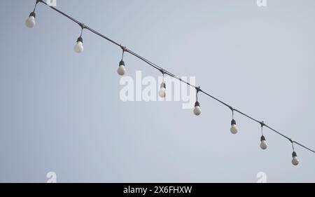 Hängende Glühlampen für den Außenbereich vor dem Hintergrund des Himmels minimaler Stil. Stockfoto