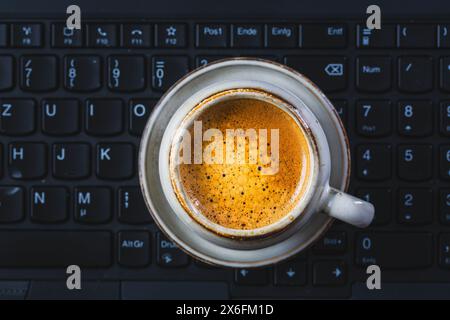 Kaffeepause im Büro, Tasse Espresso im Büro. Arbeitsplatz in einem Café oder Home Office Stockfoto