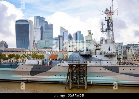 Die HMS Belfast stilllegte Royal Navy Light Cruiser, heute ein Touristenschiff, das an der Themse, den Wolkenkratzern Londons, ankert Stockfoto