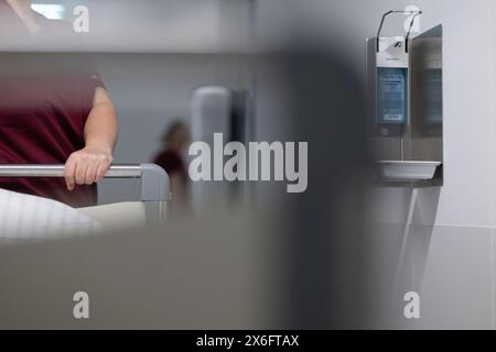 Stuttgart, Deutschland. Mai 2024. Eine Krankenschwester schiebt ein Patientenbett durch den Flur einer Krankenhausstation. Quelle: Marijan Murat/dpa/Alamy Live News Stockfoto