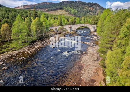 Old Bridge of Dee oder Invercauld Bridge in der Nähe der Hauptstraße von Braemar nach Ballater mit dem Fluss und Bäumen im frühen Frühjahr Stockfoto